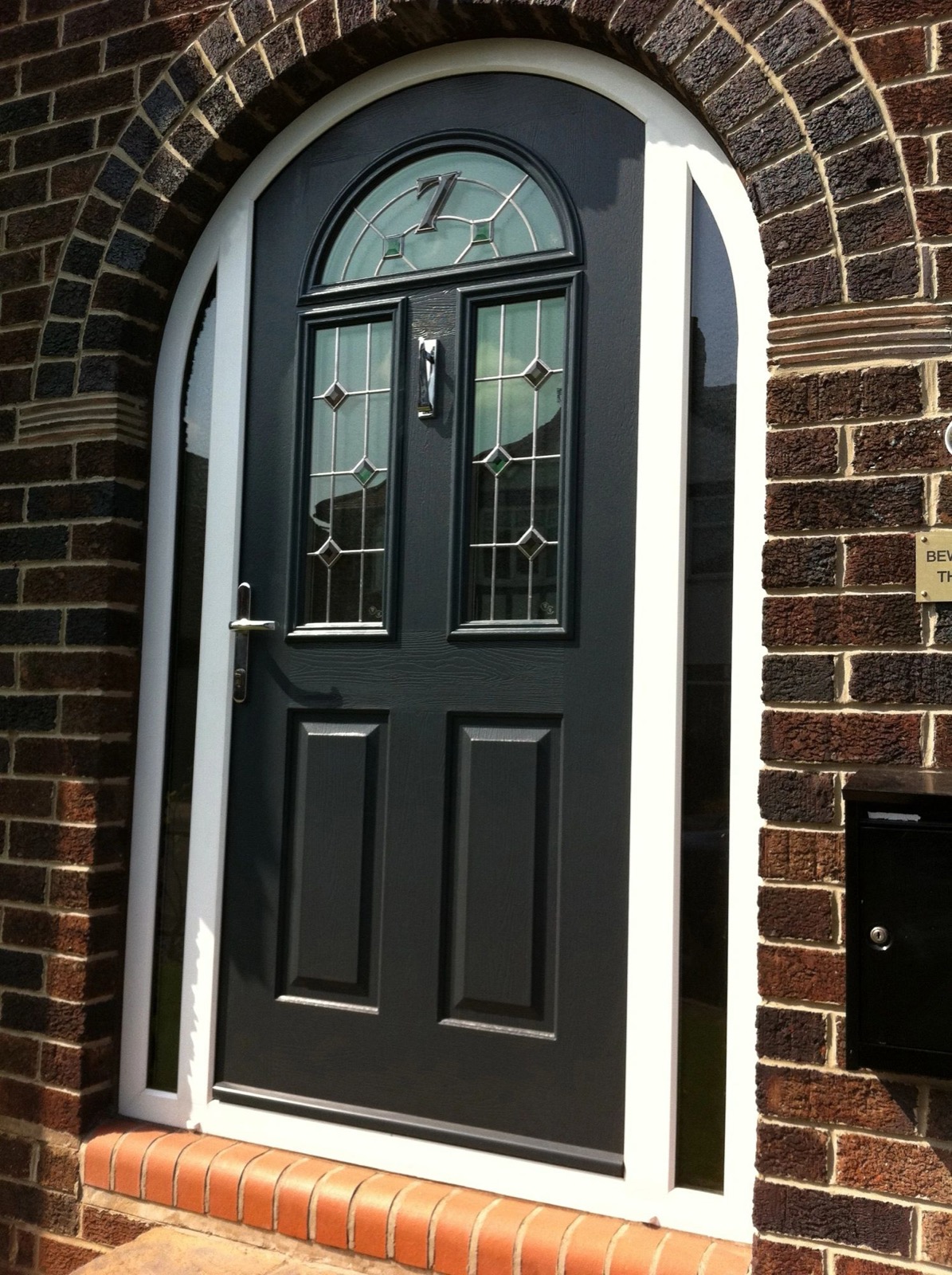 Black composite front door with an arched glazed top